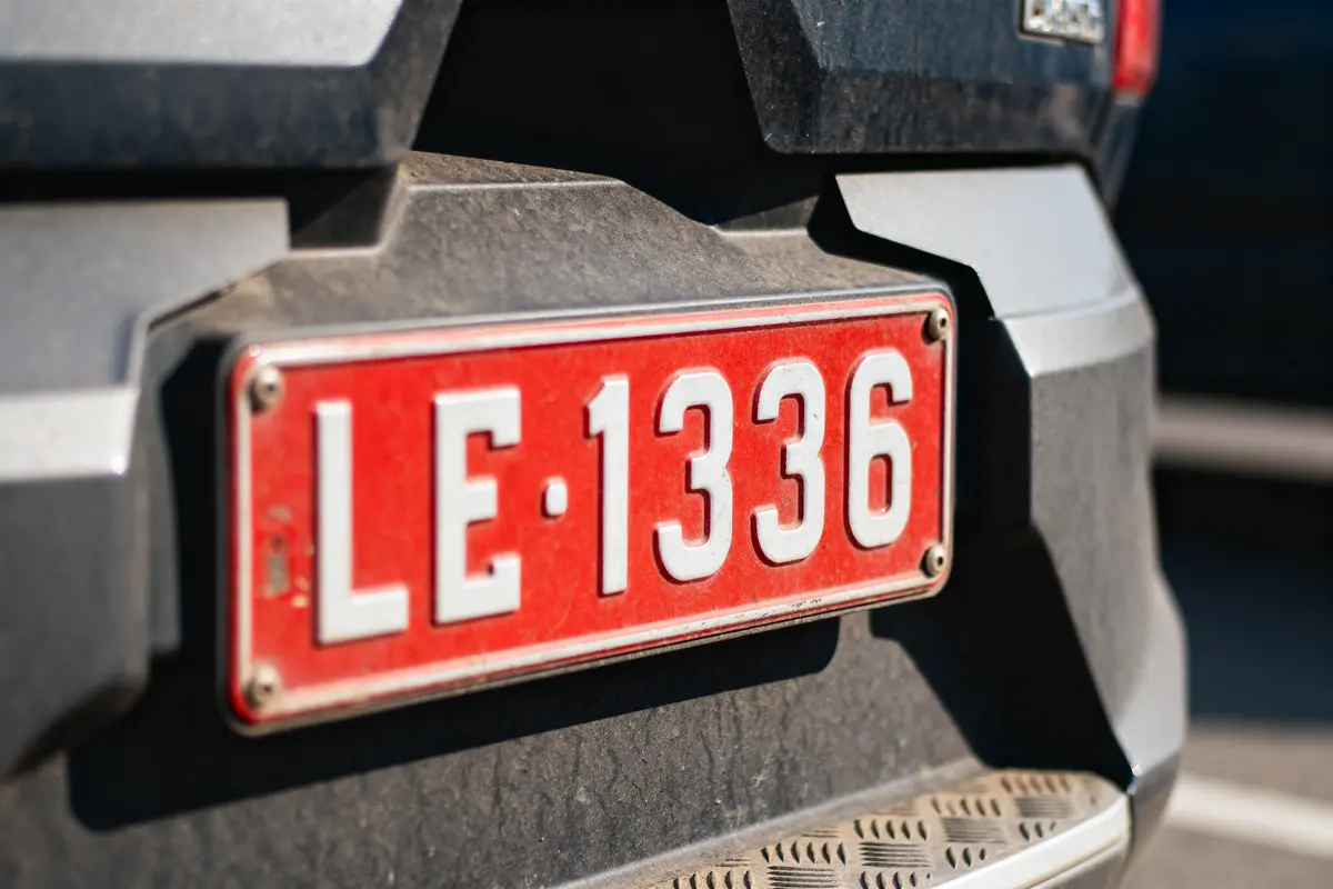 Gros plan sur une plaque d'immatriculation rouge de voiture avec numéro LE-1336