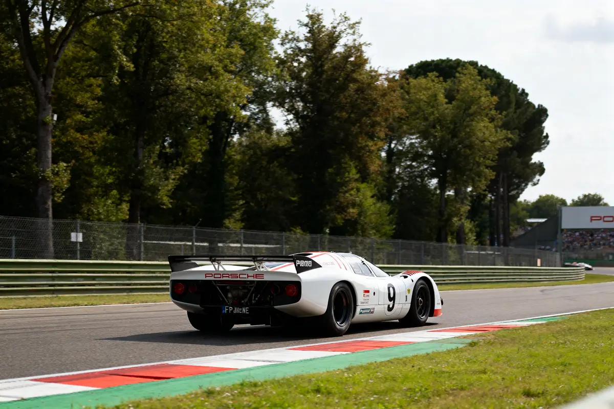 Voiture de course Porsche 917 sur circuit arboré en plein virage de piste