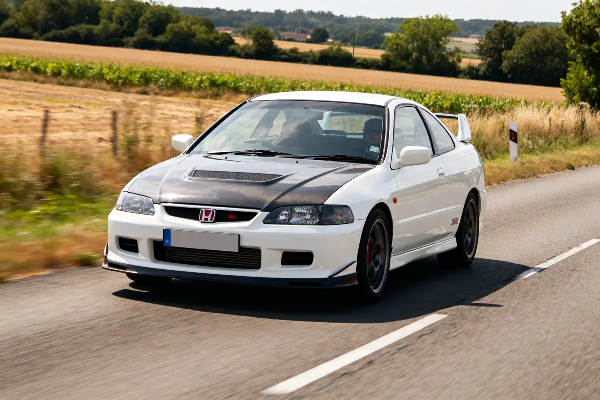 Voiture blanche ctr Honda roulant sur une route de campagne ensoleillée