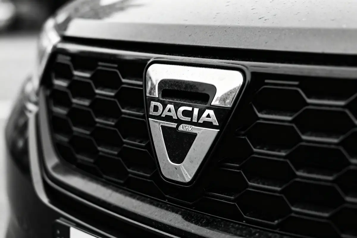 Calandre en nid d'abeille avec logo Dacia en gros plan sur une voiture noire